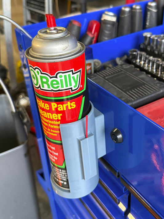 Silver can caddy with a can of aerosol spray in it magnetically attached to a blue toolbox.